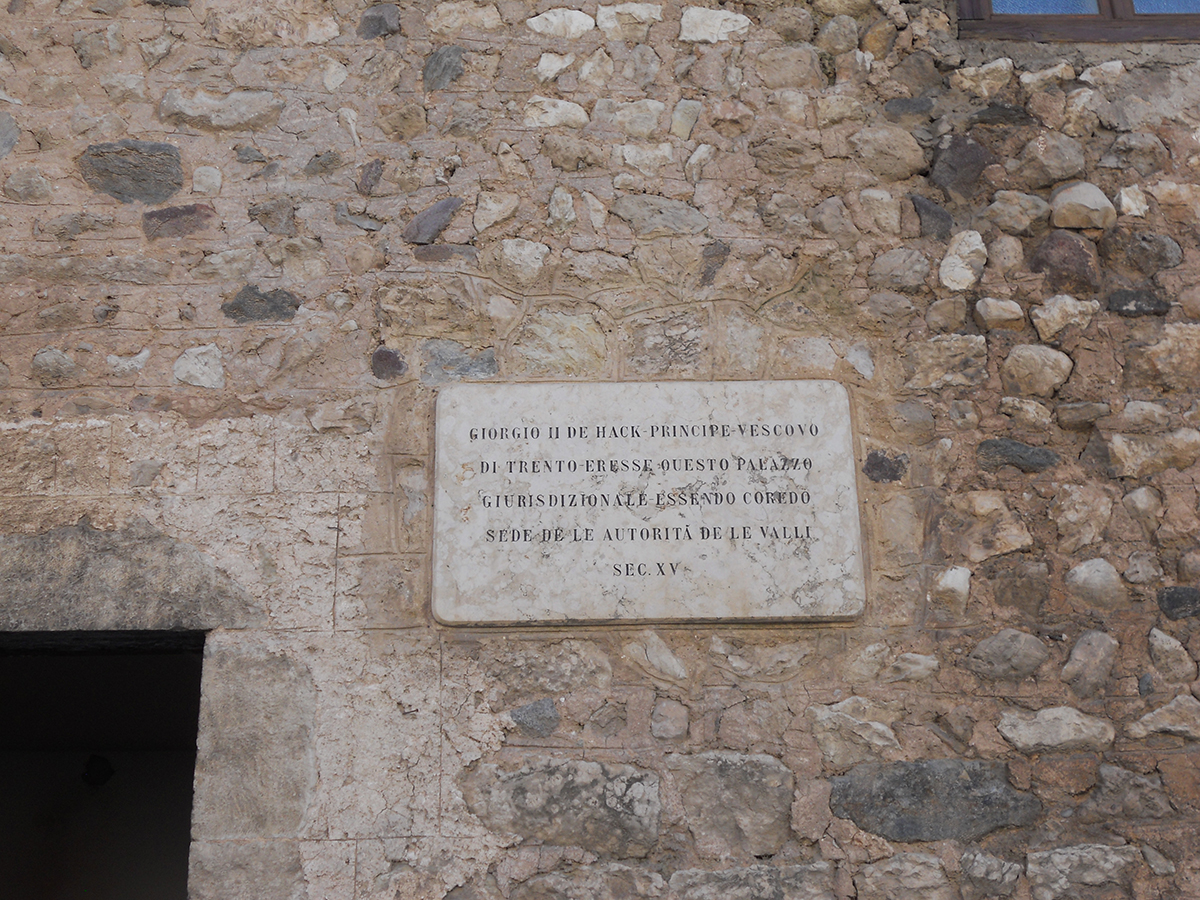 Targa commemorativa affissa sull'esterno del palazzo che ricorda il Principe Vescovo Giorgio Hack come colui che fece costruire il palazzo nel secolo XV 