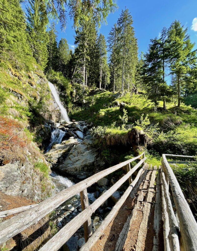 Scorcio della cascata di Palù con un ponticello di legno che si raggiunge poco lontano dai laghetti